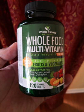 Wholesome Wellness Multivitamines Entières pour Hommes, présentation à côté d'une bouteille d'eau