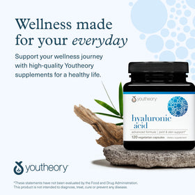 Youtheory Acide Hyaluronique capsules à côté d'un verre d'eau