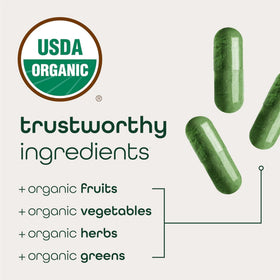 Zena Nutrition Super Greens capsules à côté de fruits et légumes